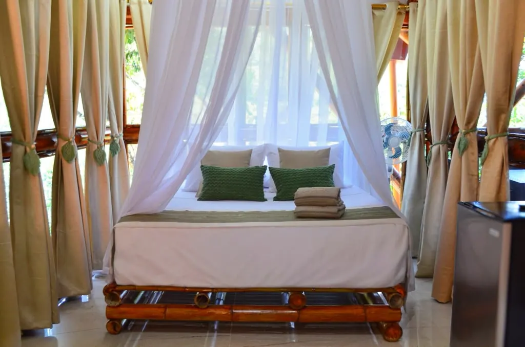 Cama de Tierra entre cortinas beige